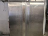 two stainless steel refrigerators that are in a room