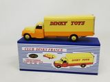 yellow and orange toy truck sitting on top of a blue box