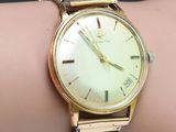 une photo d'une montre-bracelet en or au poignet d'une femme