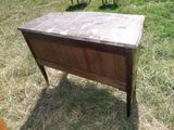 une vieille table en bois avec un plateau en marbre, posée dans l'herbe