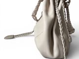 beige leather bag with braid handles on a white background