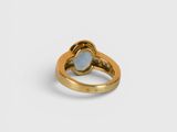 a close up of a gold ring with a blue stone