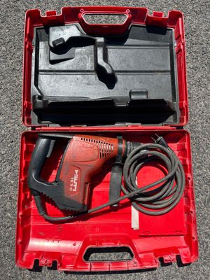 an electric drill in a red case on the ground