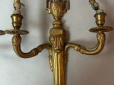 brass plated wall sconce with two candles and a bird on it