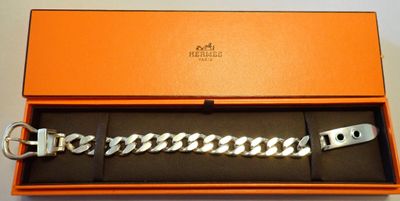 une boîte orange contenant un bracelet argenté et un porte-clés