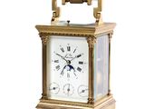 une horloge en or posée sur une surface blanche