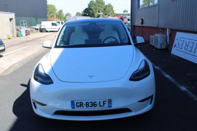 a white car parked in a parking lot next to a building