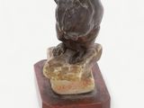 statue of a dog sitting on a rock on a white background