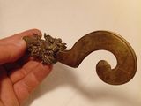 a hand that is holding a metal object with a flower on it
