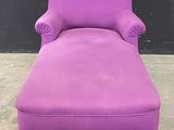 une chaise longue violette avec des pieds et des accoudoirs noirs