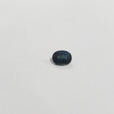 une pierre de saphir bleu sur une surface blanche