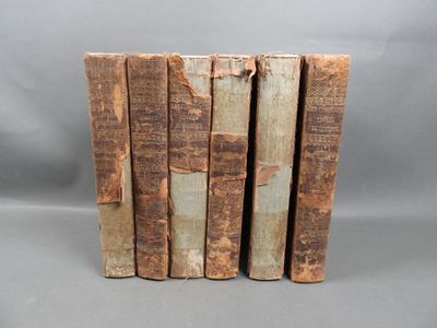 several old books stacked on top of each other on a gray surface
