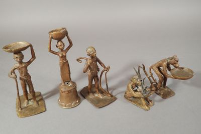 four bronze figurines of a woman with a basket on her head and a man holding a bowl on his head