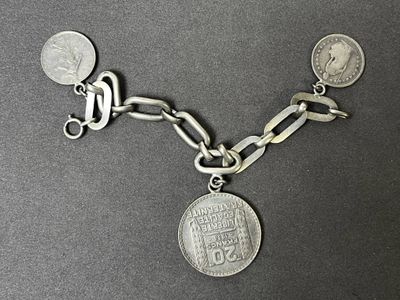 une image représentant un bracelet à chaîne en argent orné d'une pièce de monnaie