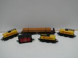 cinq petits trains miniatures alignés sur une table