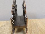 a small wooden chair that is on a wooden table