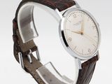 a close up of a wrist watch with a brown leather band