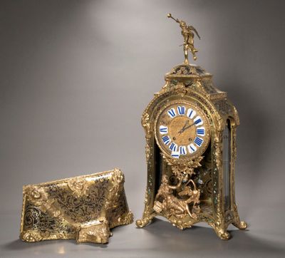 une horloge en or posée à côté d'un sac à main sur une table