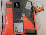 a package of clothing on a bed with a tag on it