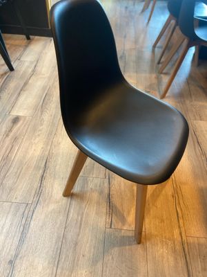 une chaise noire posée au milieu d'un parquet