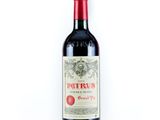 une bouteille de vin rouge posée sur une table blanche