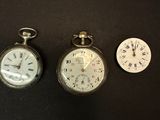 three different types of pocket watches sitting on a black surface