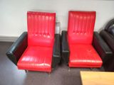 pair of red and black leather lounge chairs in a room