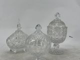 three clear glass jars with lids sitting on a white surface