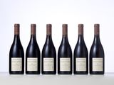 six bottles of wine lined up in a row on a table