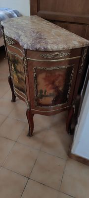 une petite table avec un plateau en marbre, dans un coin de la pièce