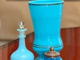 un vase en verre bleu et une bouteille en verre bleu posés sur une table