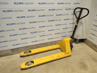 une fourche posée sur une palette devant un mur