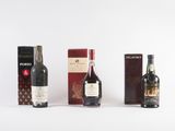 three bottles of wine and a box of chocolates on a white surface