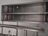 a kitchen with a sink and a metal shelf above it