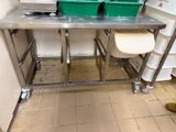 une photo d'une table en acier inoxydable sur laquelle sont posées deux poubelles vertes