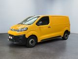 Une camionnette jaune est garée dans une pièce blanche.