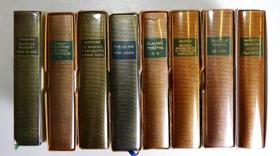 plusieurs vieux livres sont alignés sur une étagère