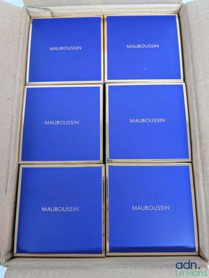 six aimants carrés bleus dans une boîte en carton posée sur une table