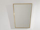 un miroir à cadre doré accroché au mur d'une pièce blanche