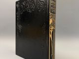 un livre noir posé sur une table blanche
