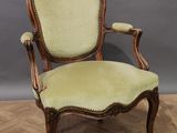 a green upholstered chair on a wooden floor