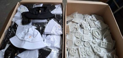 deux cartons contenant des casquettes et des t-shirts, qui se trouvent dans un carton