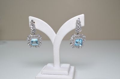 pair of blue topaz and diamond earrings on a white display stand