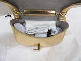 a gold purse with a white shirt inside of it
