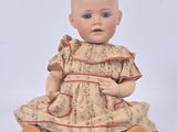 an image of a baby doll sitting on the ground with a white background