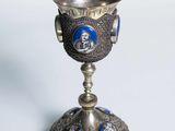 une coupe argentée et bleue posée sur un socle en argent