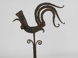 an old iron rooster on a stand with a white background