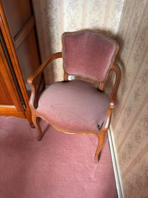 a pink chair sitting in a corner of a room