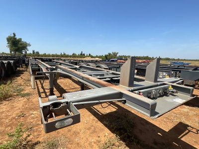 une grande structure métallique située au milieu d'un champ de terre battue
