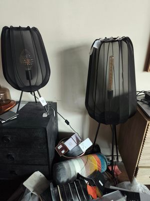 une pièce encombrée avec un bureau, une lampe et d'autres objets